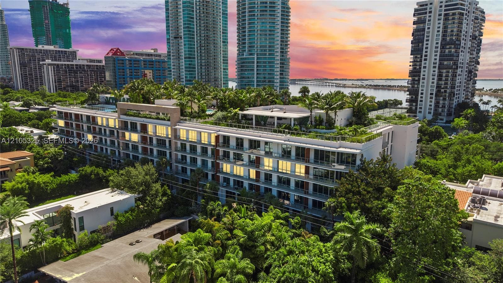 Contemporary multi-story building featuring multiple balconies and rooftop landscaping