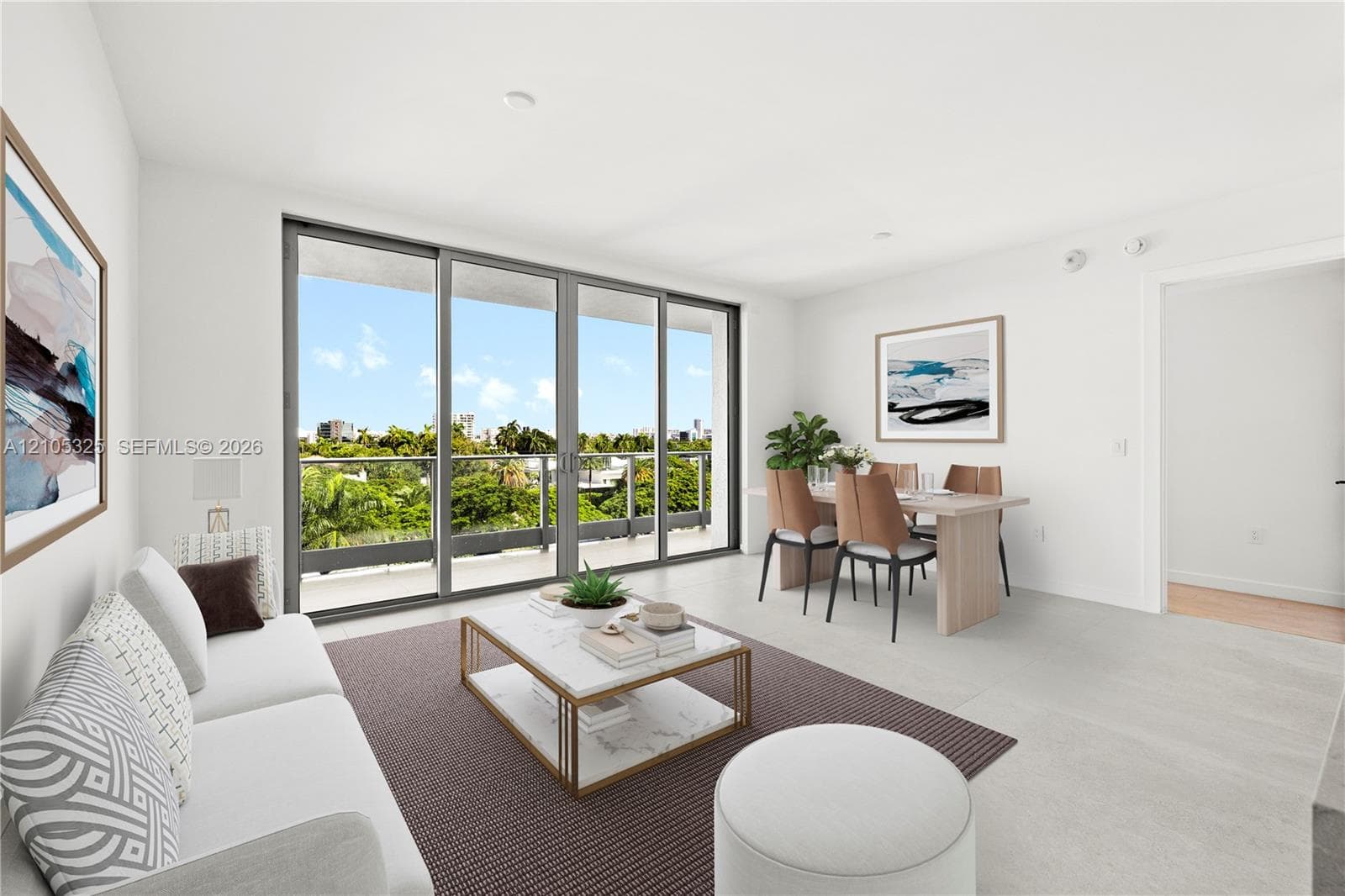 Spacious living area featuring large sliding glass doors, light-toned flooring, a balcony with glass railings, and recessed lighting