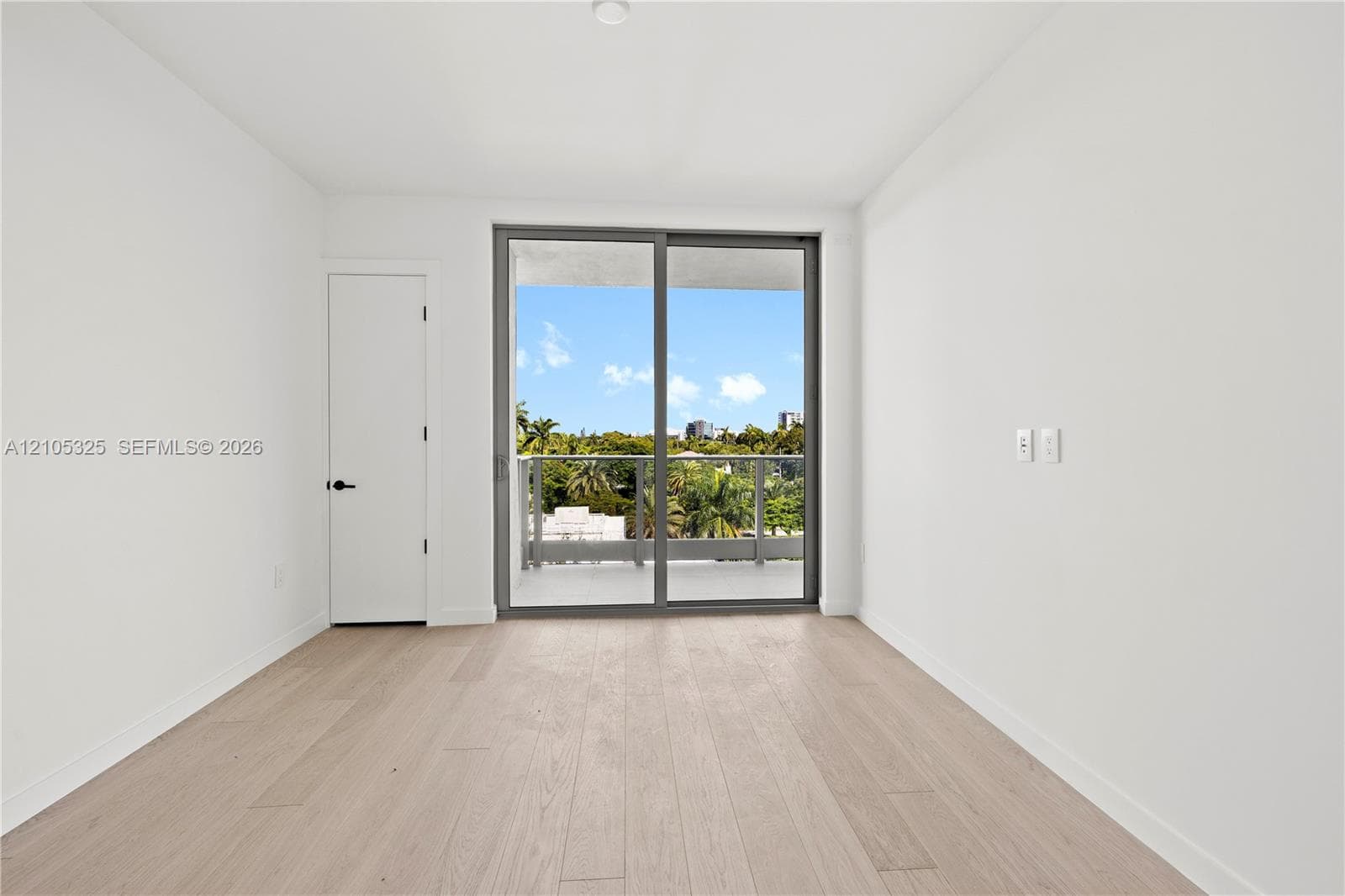 Wood-finish flooring, white walls, and a recessed ceiling light