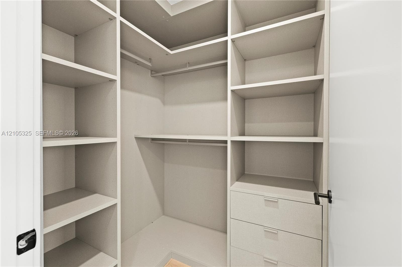Built-in closet system featuring multiple shelves, hanging rods, and integrated drawers
