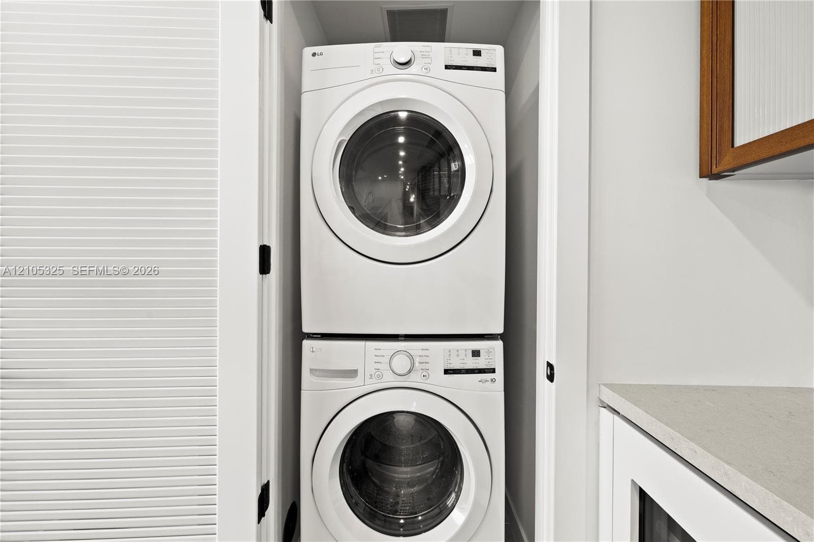 Stackable washer and dryer within a dedicated utility alcove