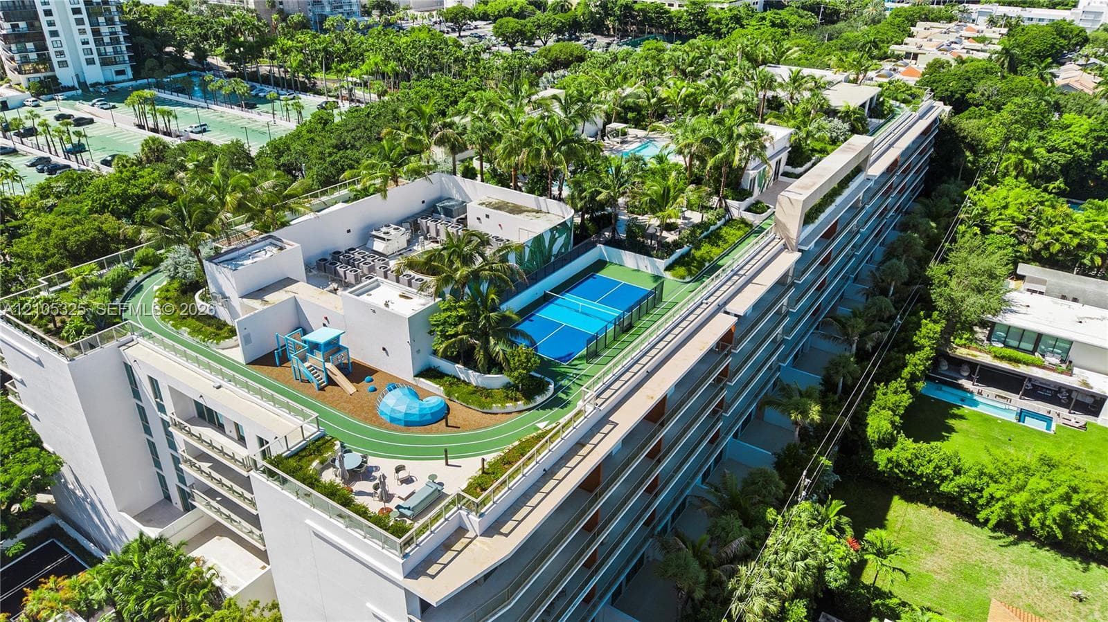 Rooftop recreation area featuring a tennis court, a running track, and a dedicated play area