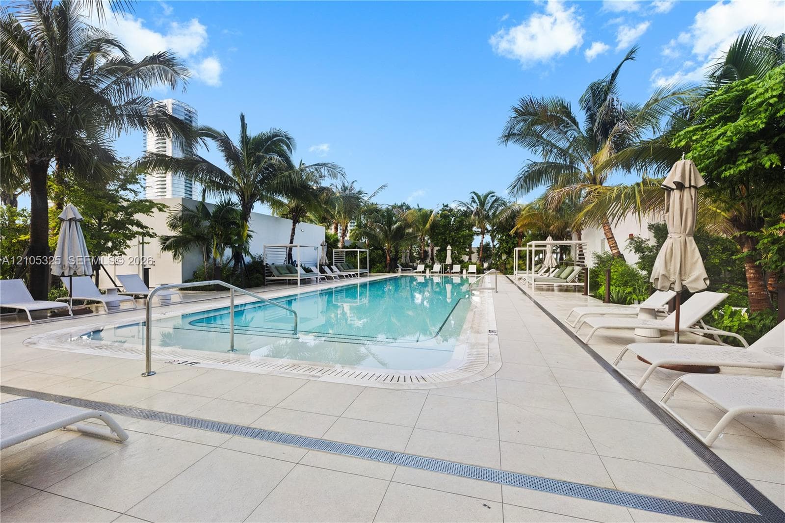 Outdoor swimming pool with integrated spa and surrounding non-slip tile deck