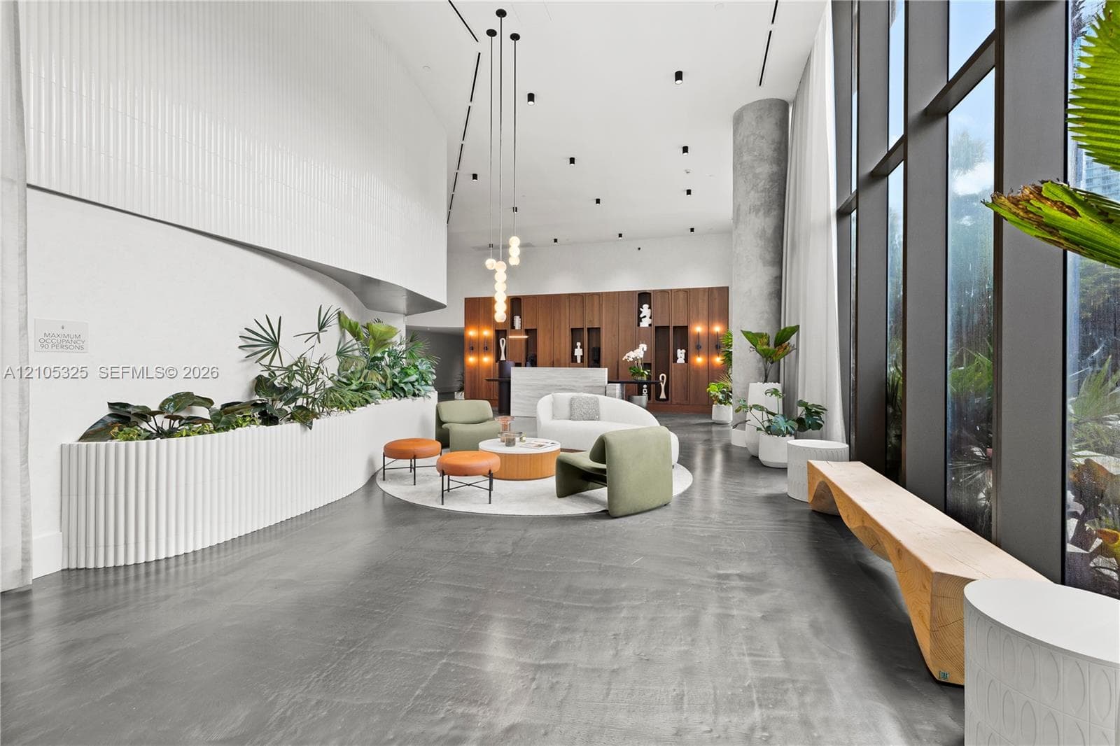 Modern lobby featuring soaring ceilings with recessed lighting, polished concrete flooring, and expansive floor-to-ceiling glazing