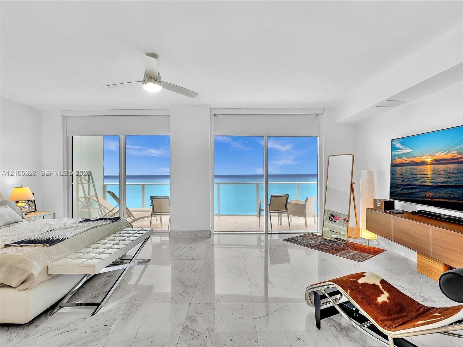 Wake up to breathtaking ocean views from the comfort of your bed in this spacious primary suite, featuring floor-to-ceiling sliding glass doors with direct access to a private balcony.