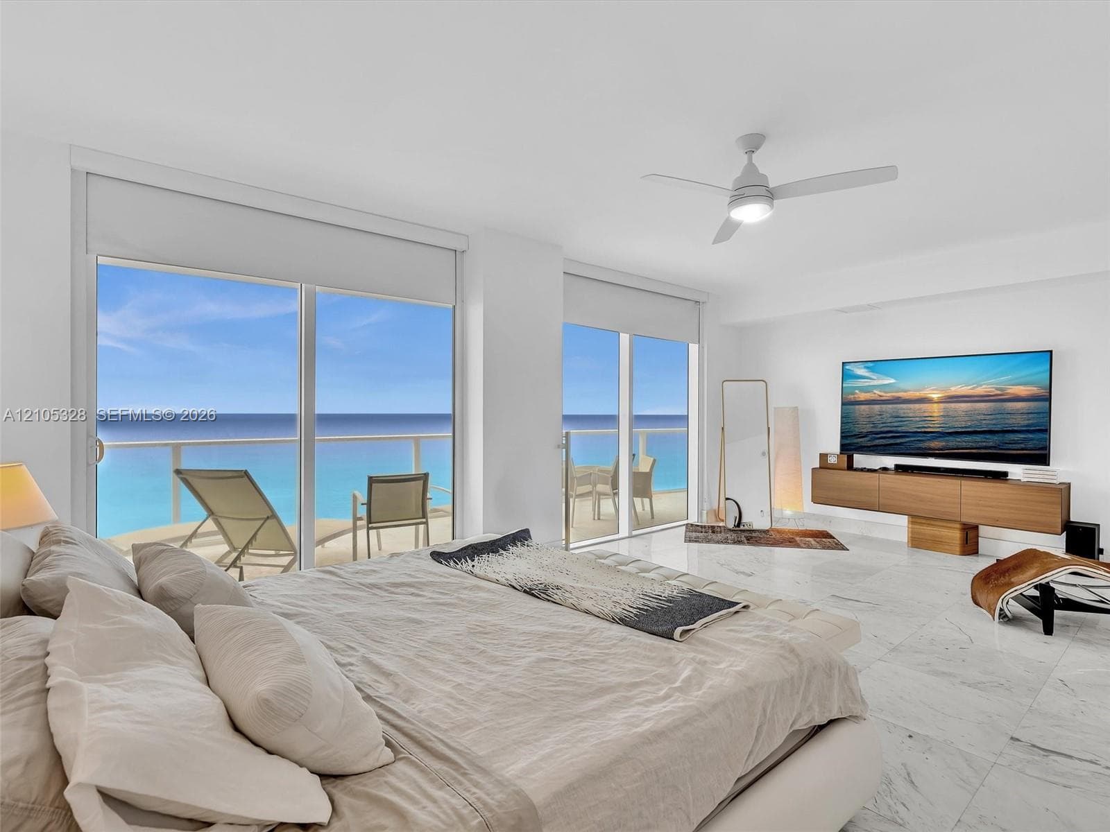 Wake up to breathtaking ocean views from the comfort of your bed in this spacious primary suite, featuring floor-to-ceiling sliding glass doors with direct access to a private balcony.