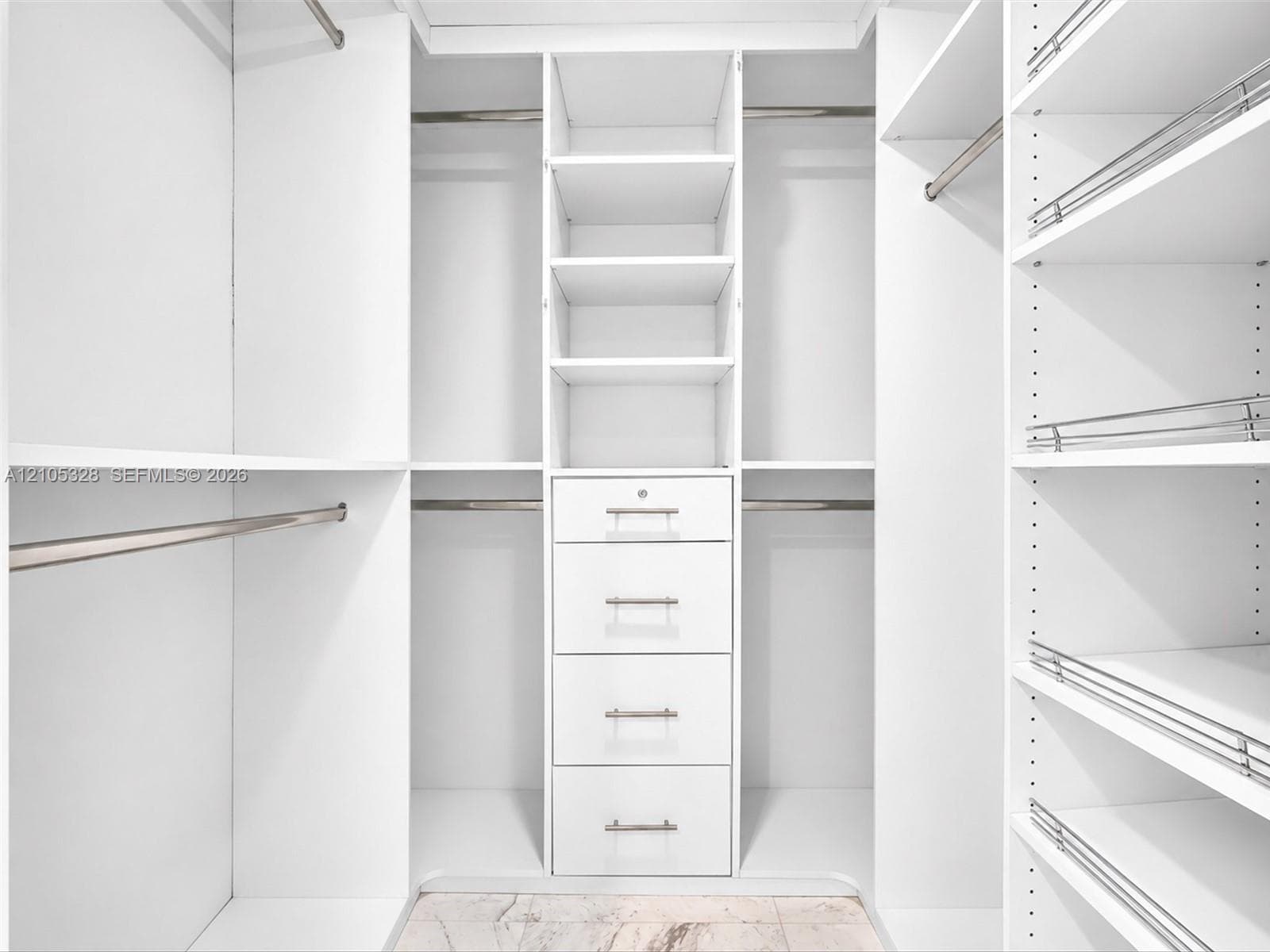 Luxurious custom-designed white closet system featuring generous hanging space, adjustable shelving, and built-in drawers with polished hardware for elegant, organized storage.