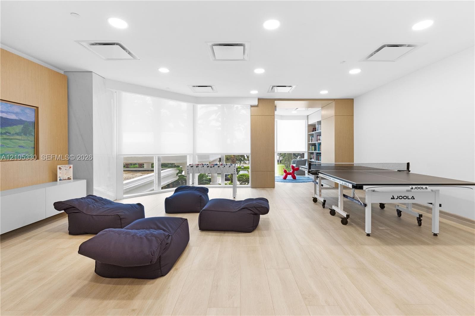 Recessed ceiling lighting, light wood-finish flooring, built-in cabinetry, and expansive windows with roller shades