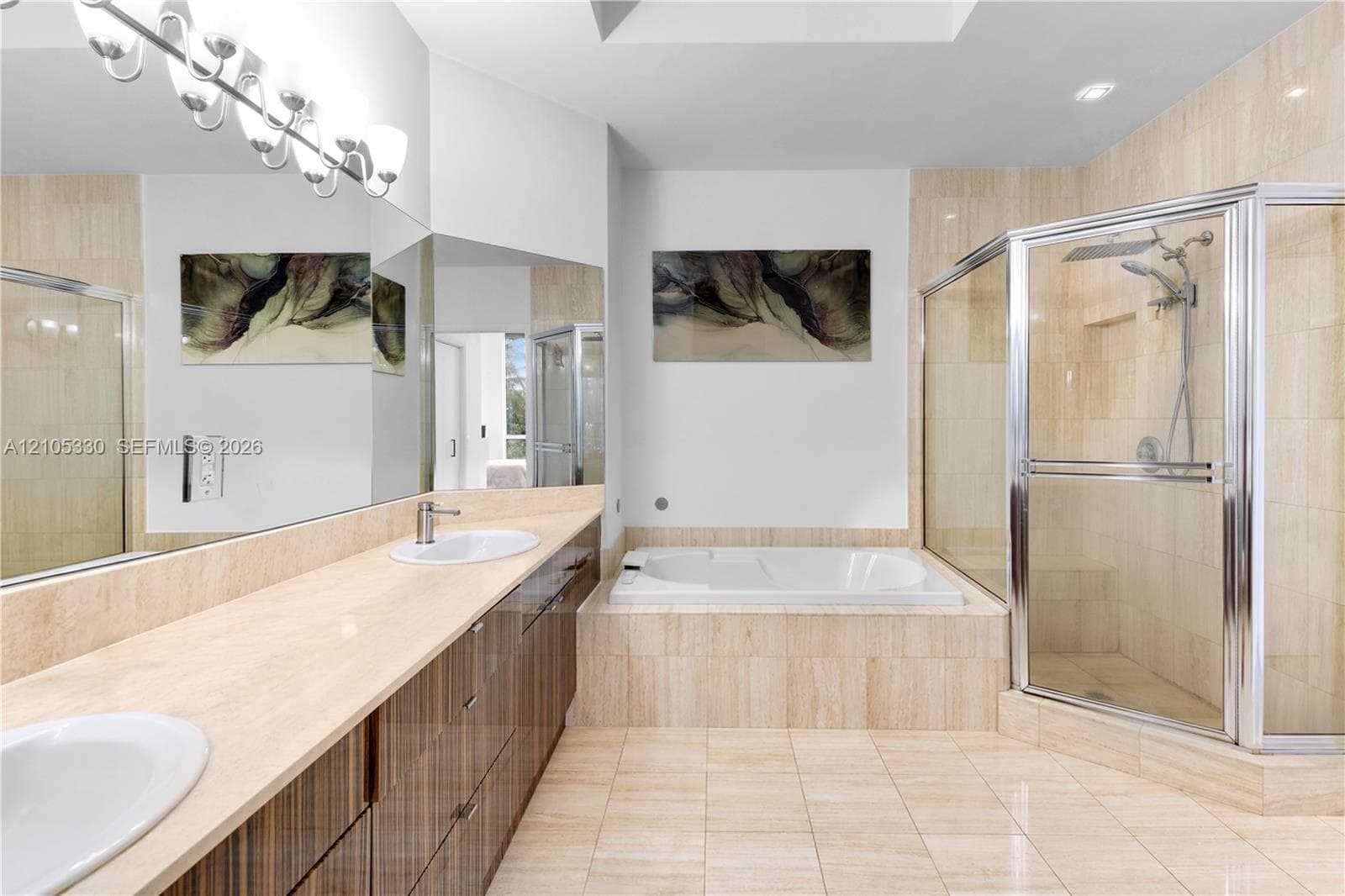 Dual vanity with undermount sinks, integrated soaking tub, tiled shower enclosure, and tiled flooring