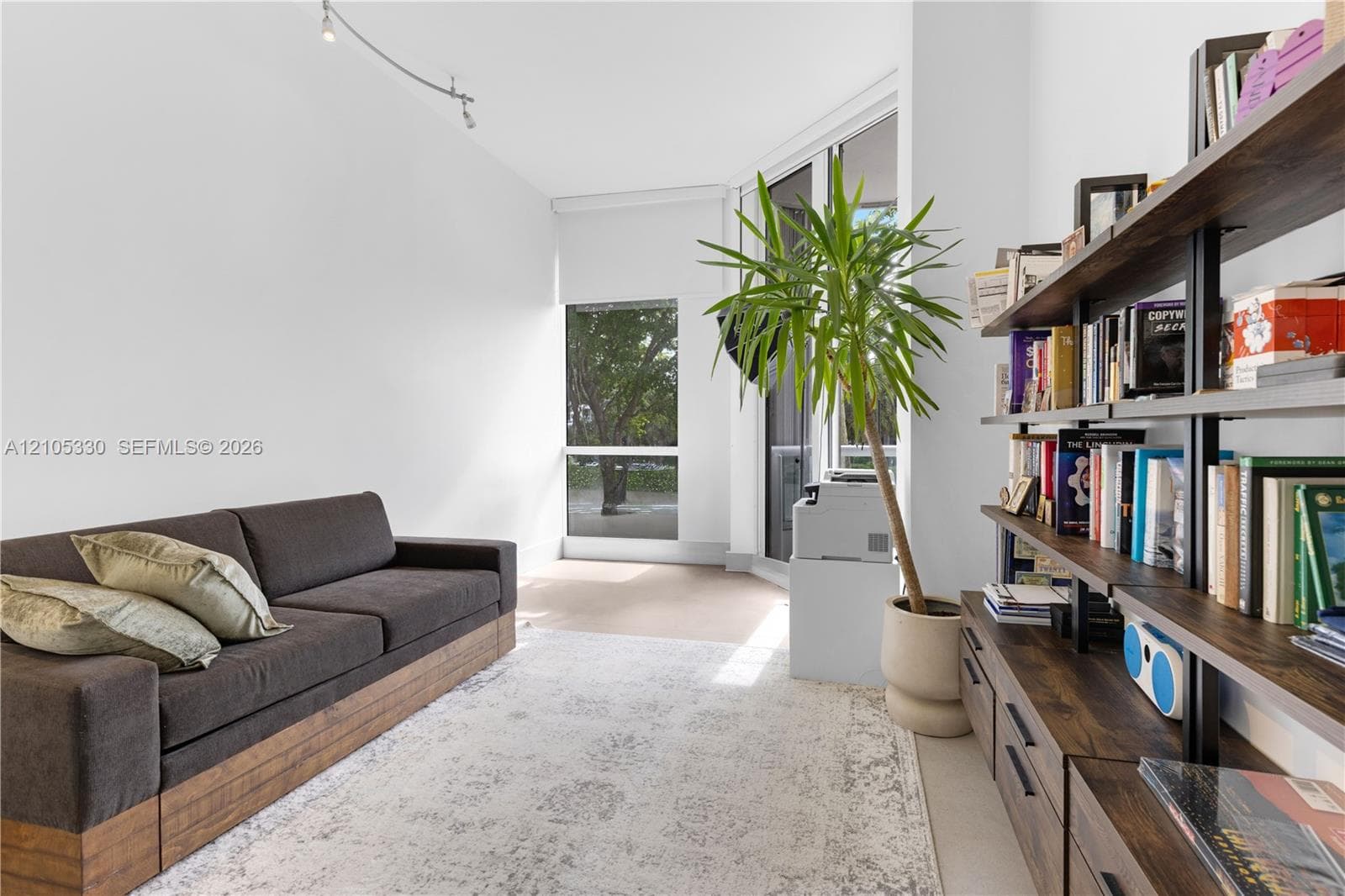 White walls, recessed lighting, and a full-height window create a bright interior