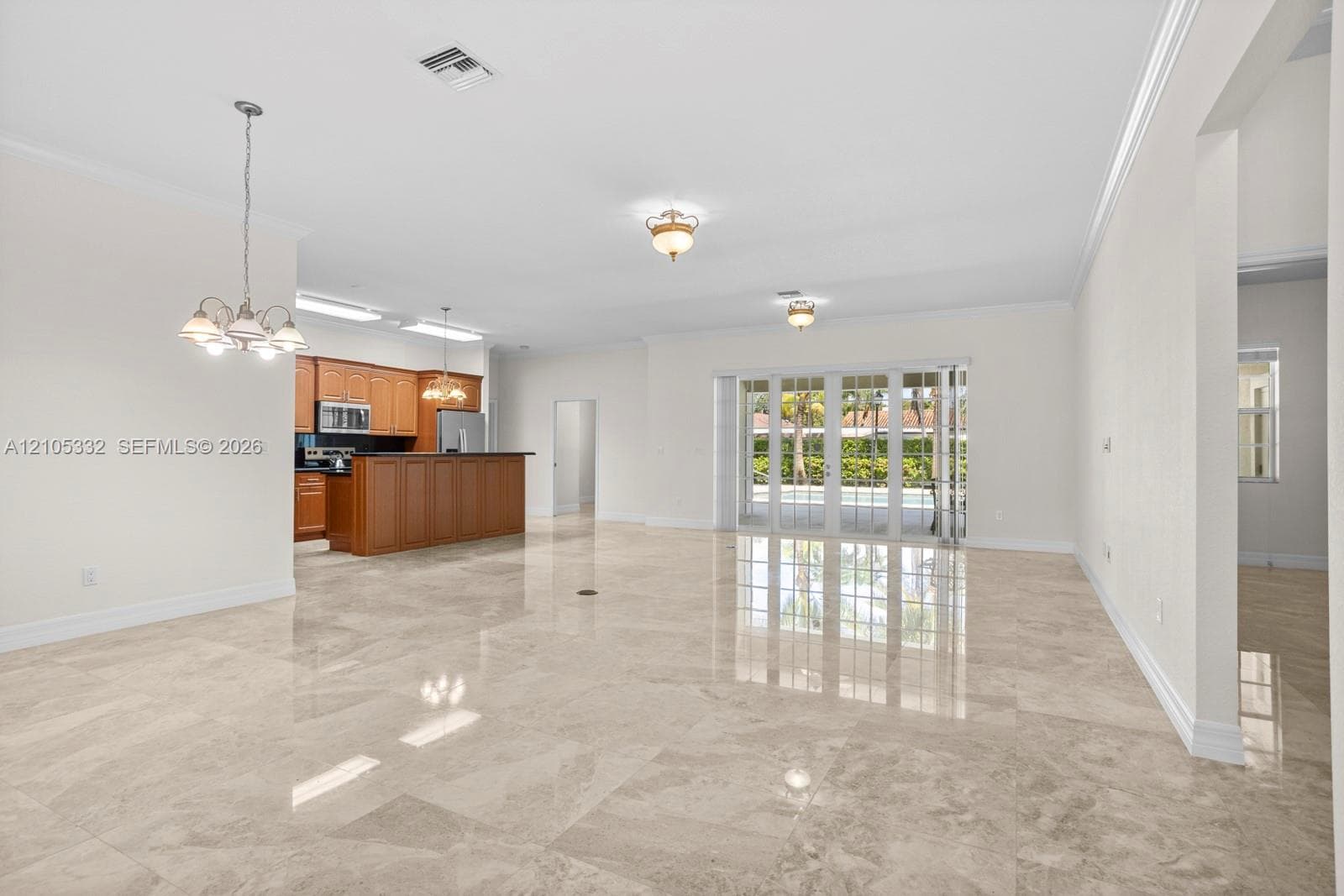 Light-toned tile flooring, white walls, and crown molding throughout