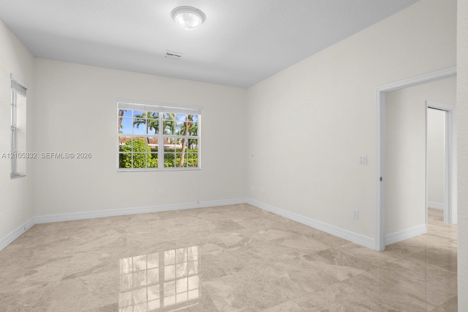 Polished tile flooring with subtle veining, recessed ceiling light fixture, and multiple windows providing natural light