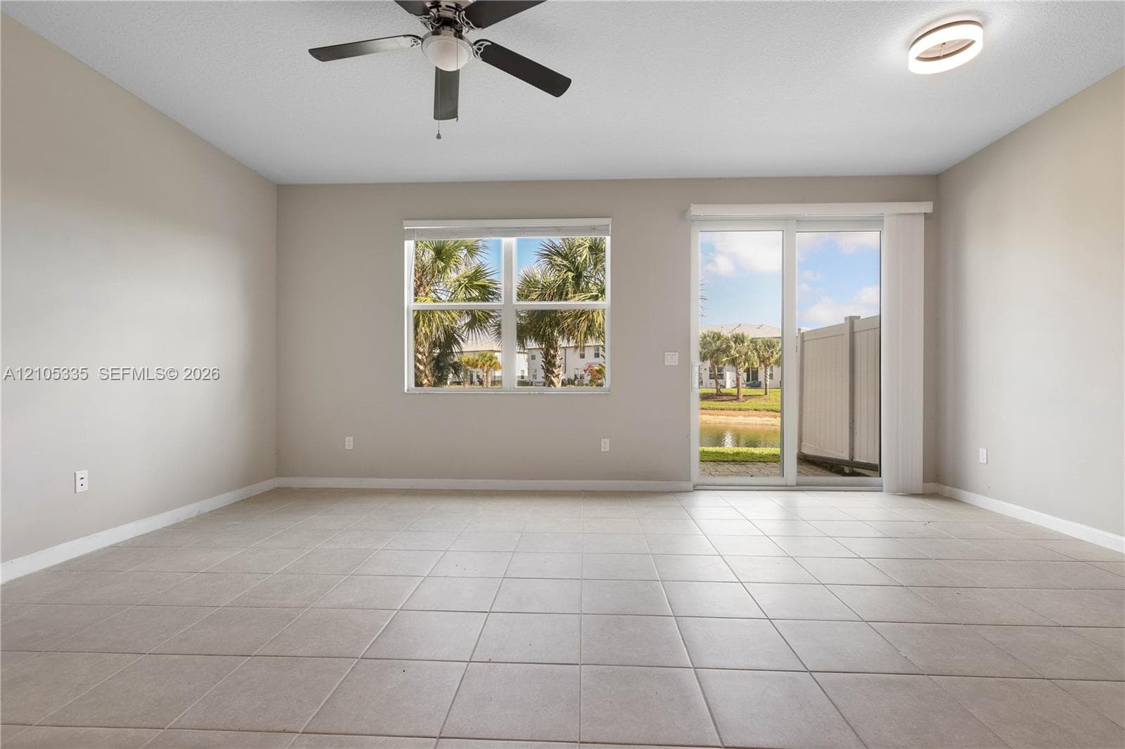 Neutral-toned tile flooring, white walls, ceiling fan, contemporary ceiling light fixture, and sliding glass doors