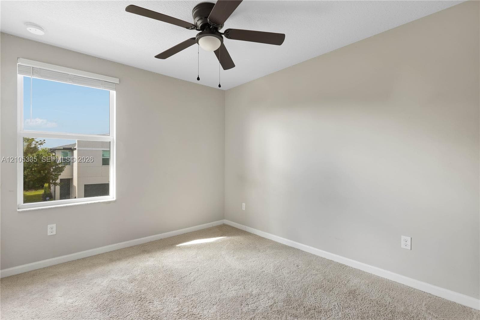 Carpeted room featuring a ceiling fan with light, a recessed ceiling light, and a window with blinds