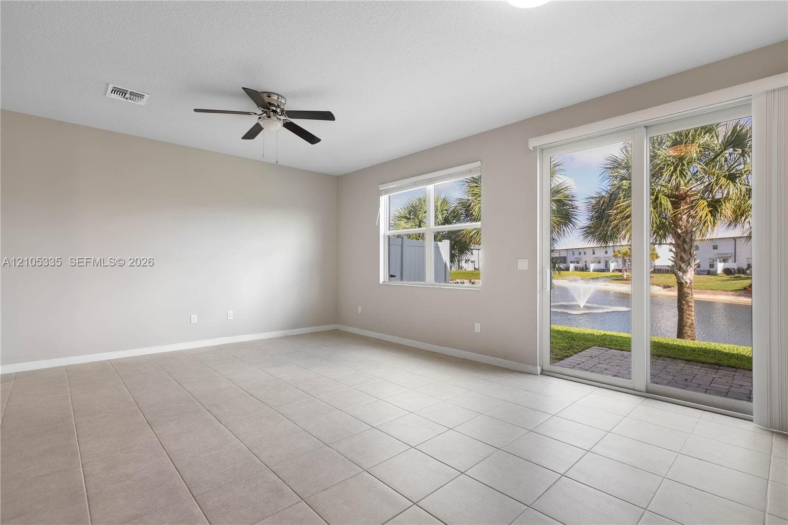 Tile flooring, ceiling fan, large window, sliding glass door, and paver patio