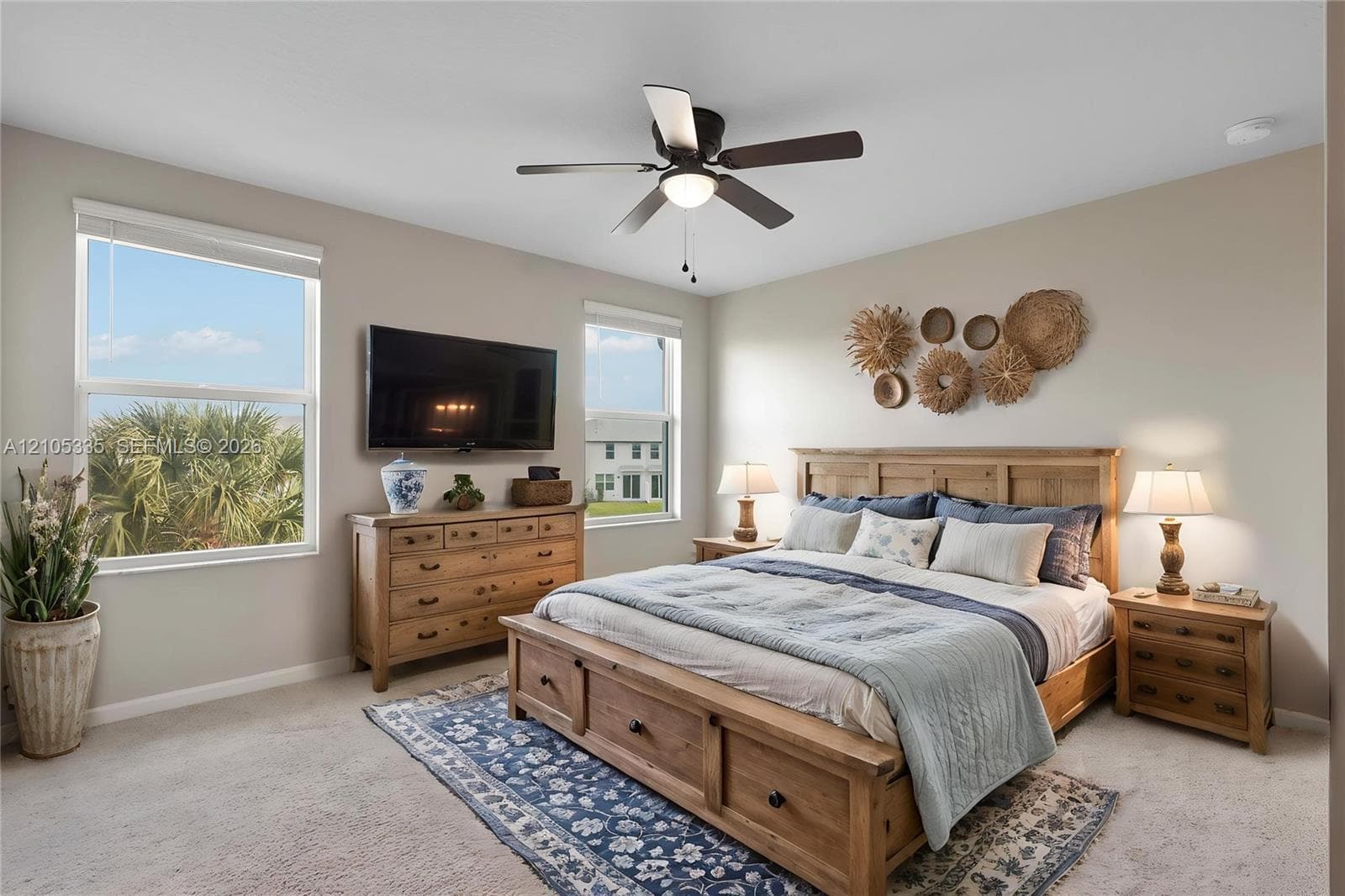 Spacious room featuring multiple windows, a ceiling fan with integrated lighting, and neutral wall paint