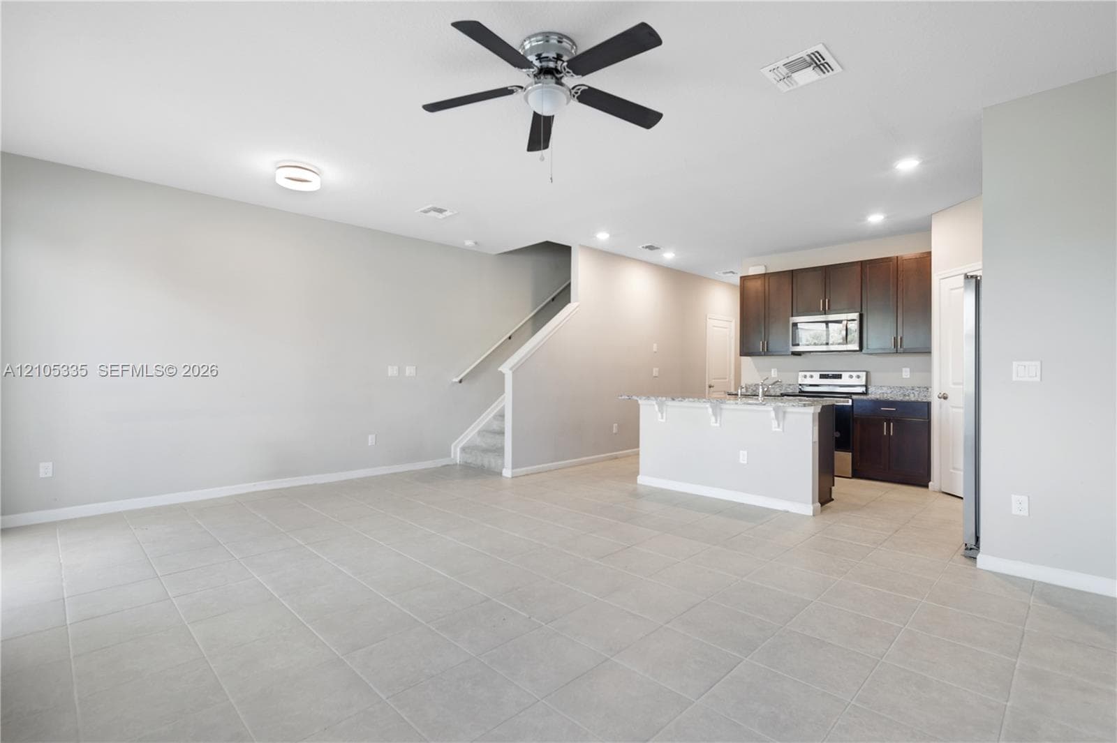 Open-concept living area featuring tile flooring, a ceiling fan, and recessed lighting
