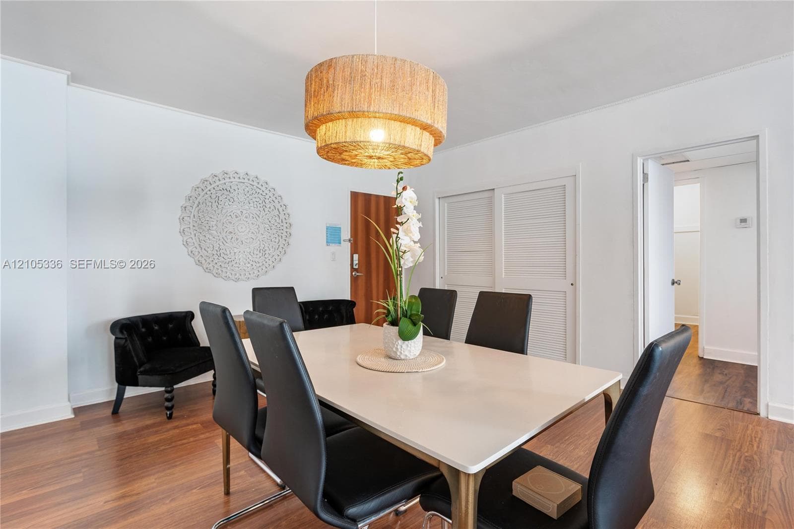 Wood-finish flooring, multi-tier woven drum pendant lighting, and louvered double-door closet cabinetry