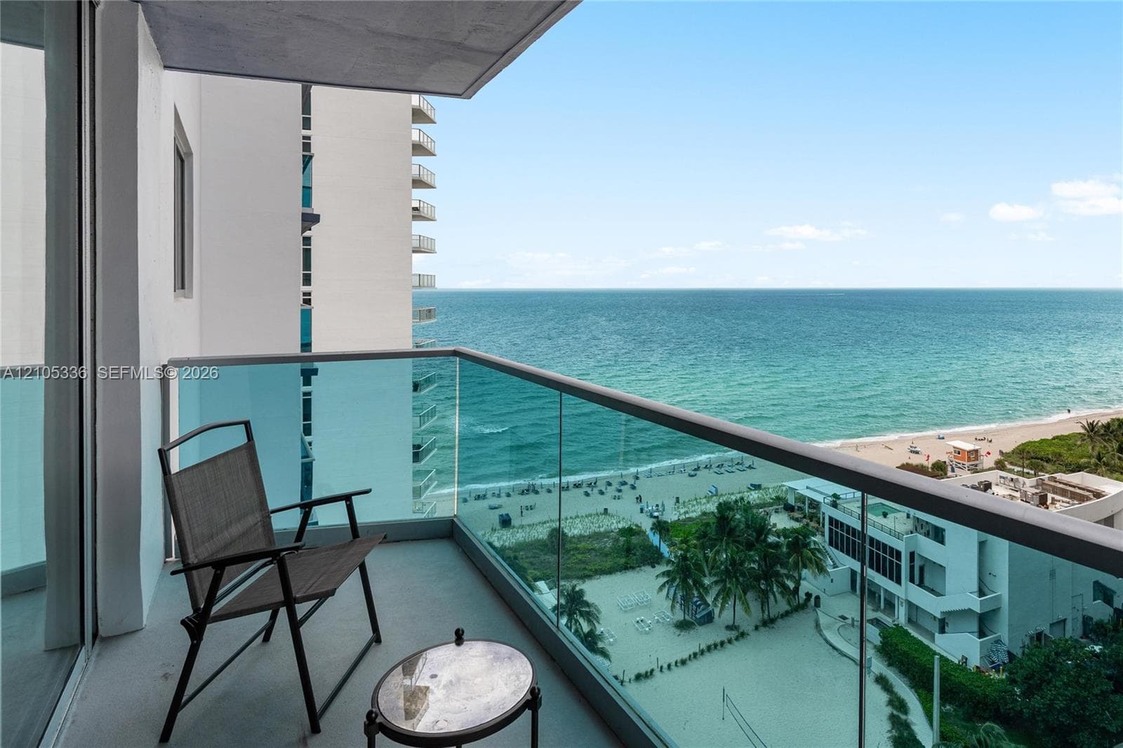 Private balcony featuring glass-panel railings and concrete flooring with an unobstructed ocean backdrop