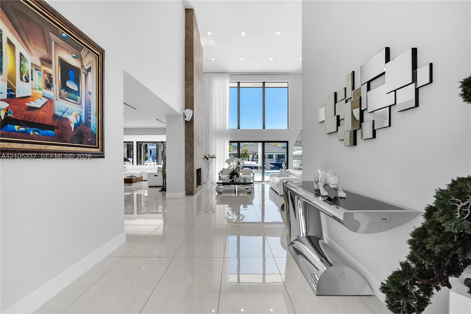 Grand foyer featuring high ceilings, oversized polished floor tiles, recessed lighting, and a floor-to-ceiling accent wall
