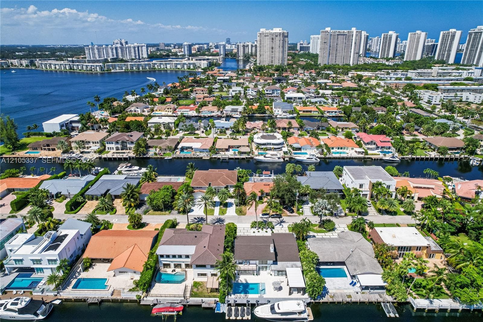 Aerial perspective featuring waterfront residential properties with private swimming pools, individual boat slips, and deep-water canal access