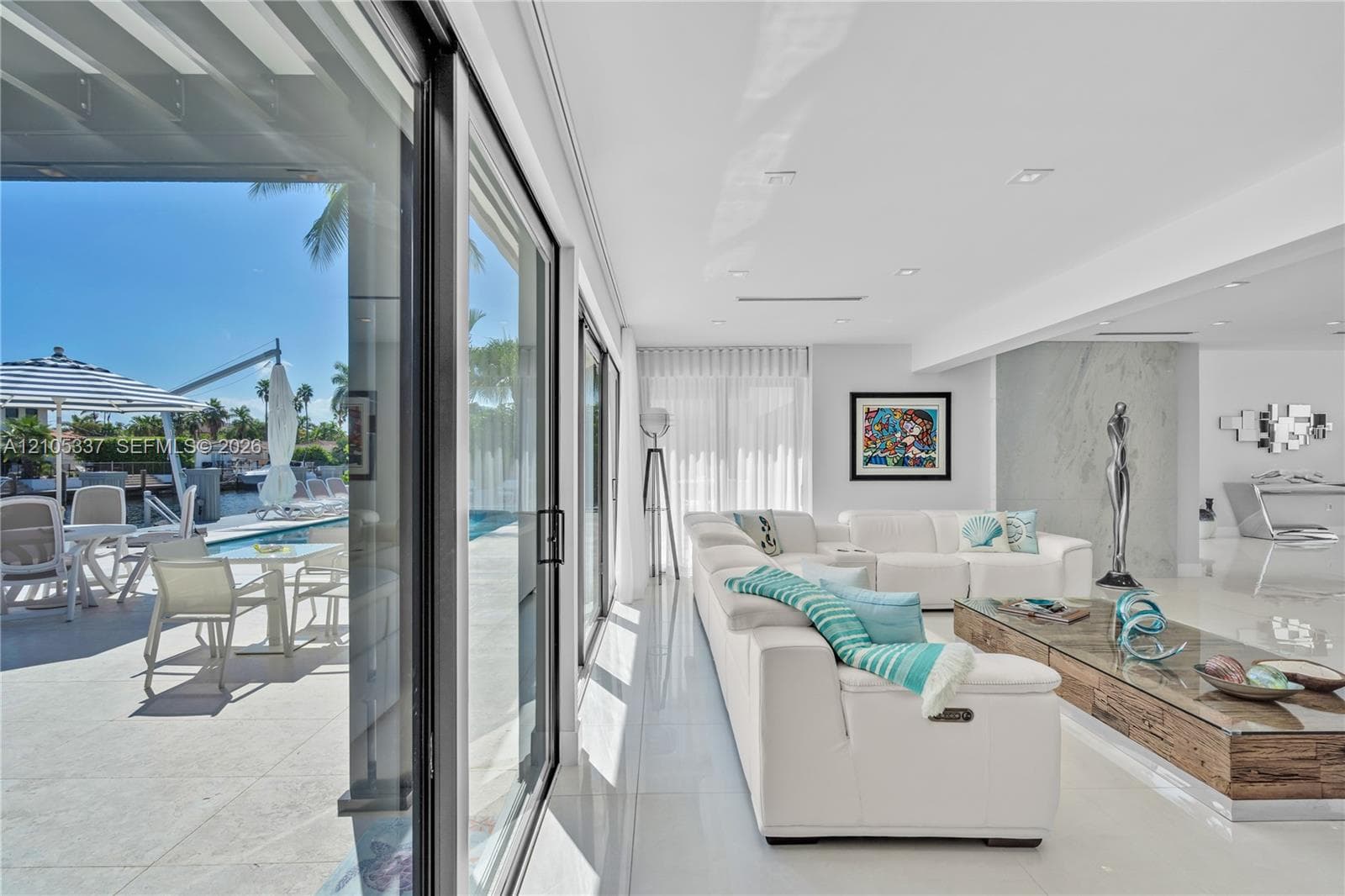 Floor-to-ceiling sliding glass doors, polished tile flooring, recessed ceiling lighting, and a large-format feature wall with integrated stone-finish paneling