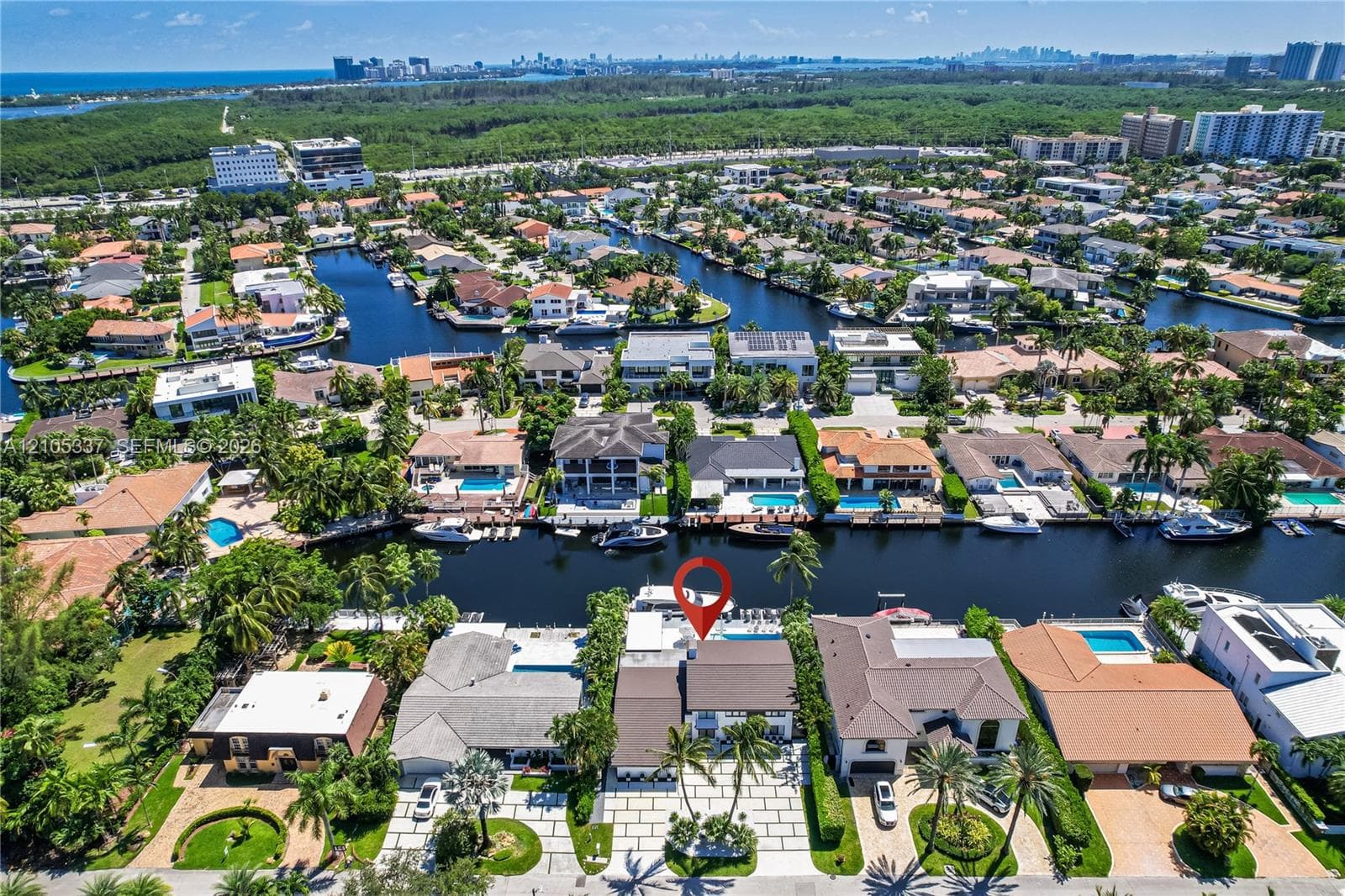 Waterfront property featuring a private boat dock, swimming pool, and paver driveway