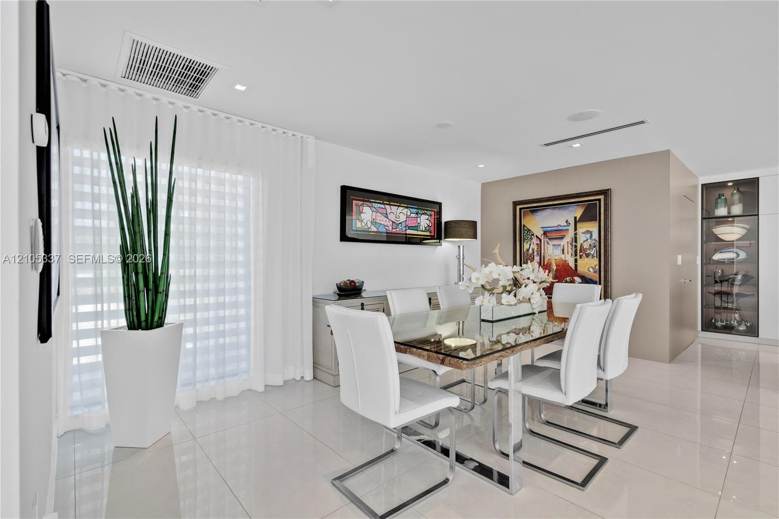 Large-format tile flooring, recessed ceiling lighting, and built-in glass-front display cabinetry