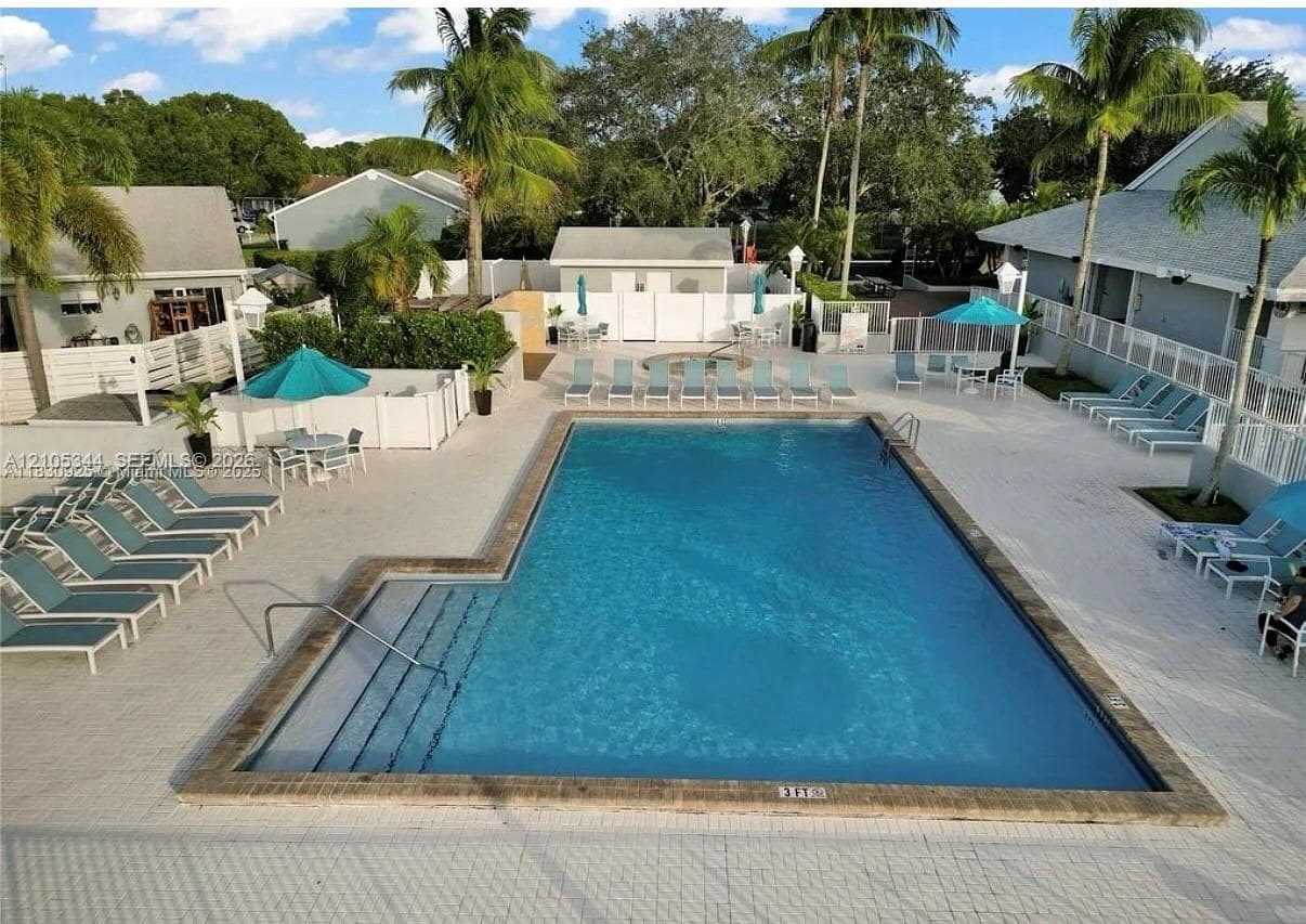 Rectangular swimming pool with integrated steps, surrounded by a paved deck