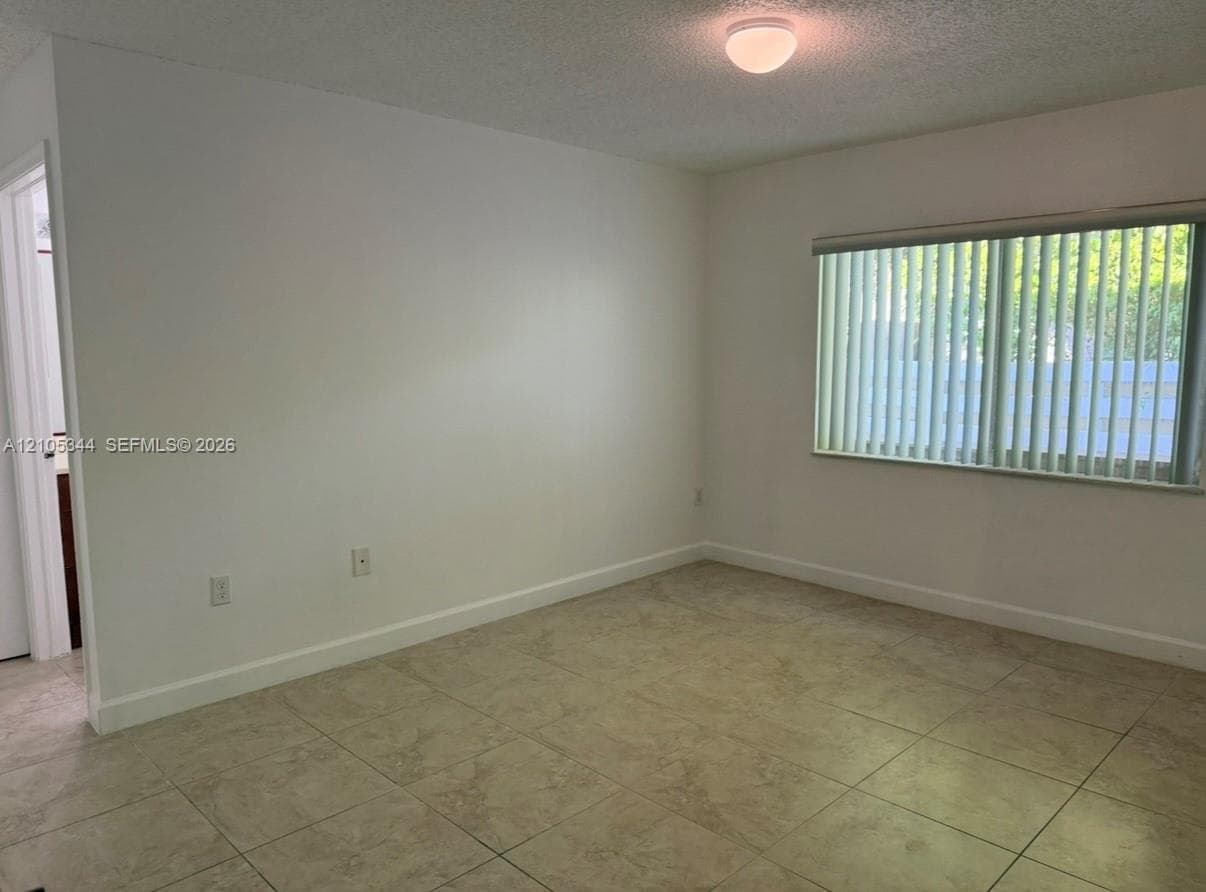 Neutral wall color, ceramic tile flooring, horizontal window blinds, and flush mount ceiling light fixture