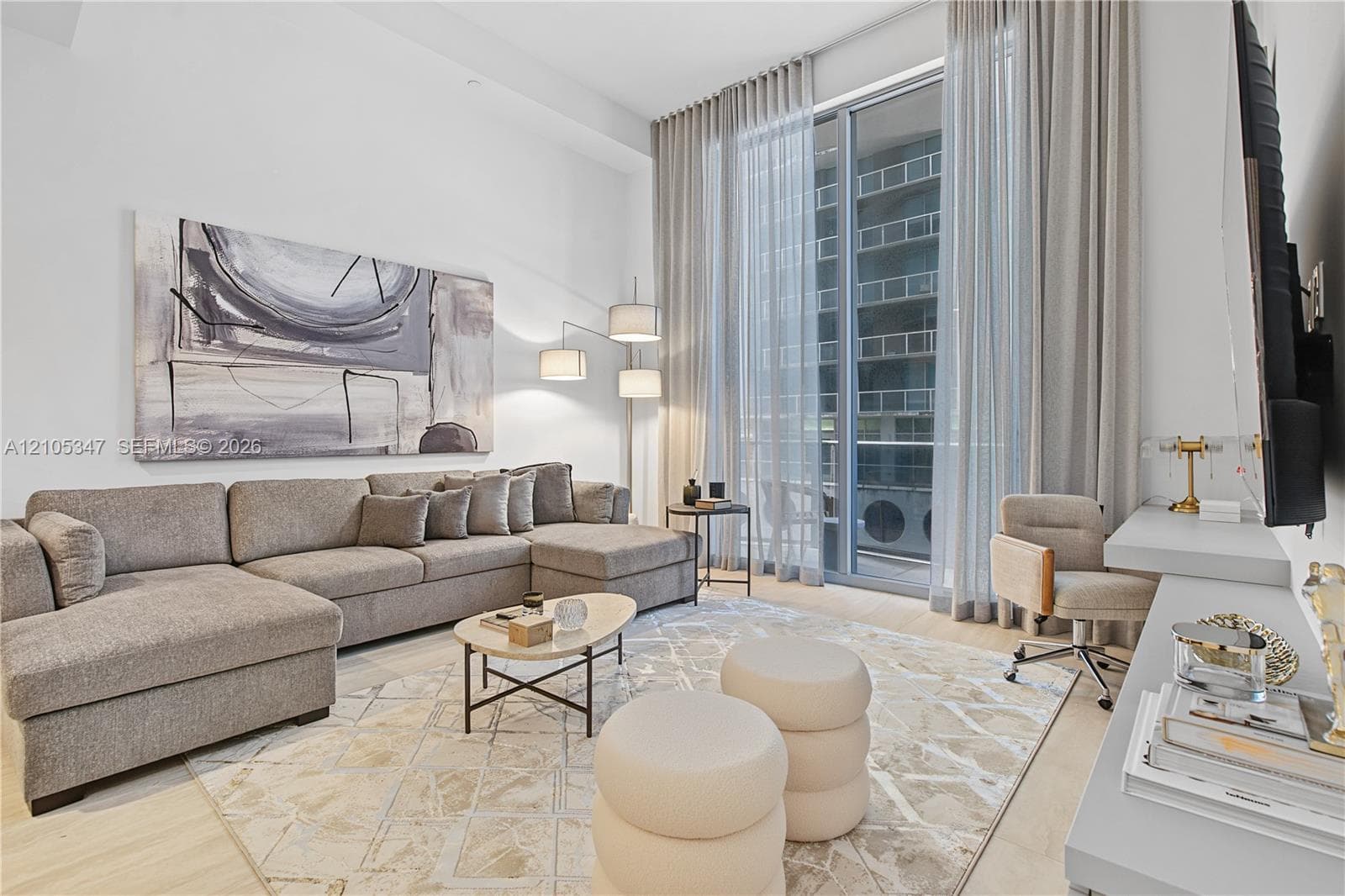Expansive living area with high ceilings, large format flooring, and floor-to-ceiling windows