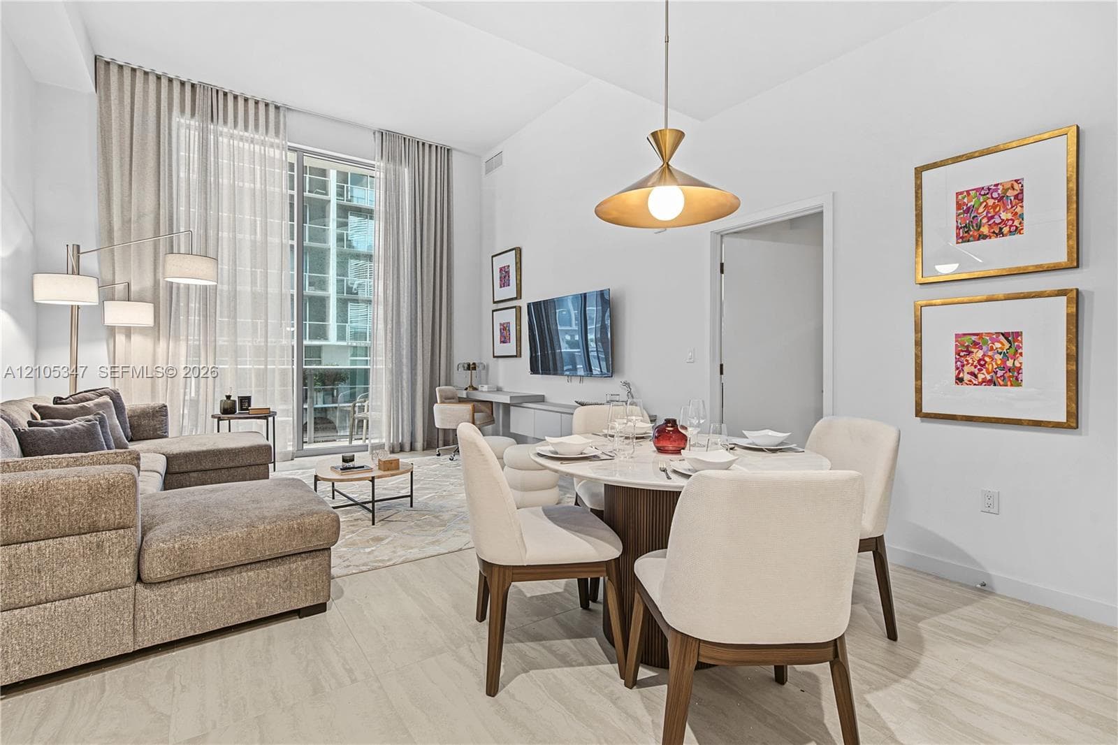 Expansive glass sliding doors, light wood-finish flooring, recessed lighting, modern pendant light fixture, and a built-in desk area