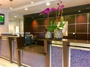 Reception counter with a dark countertop and blue mosaic tile accents