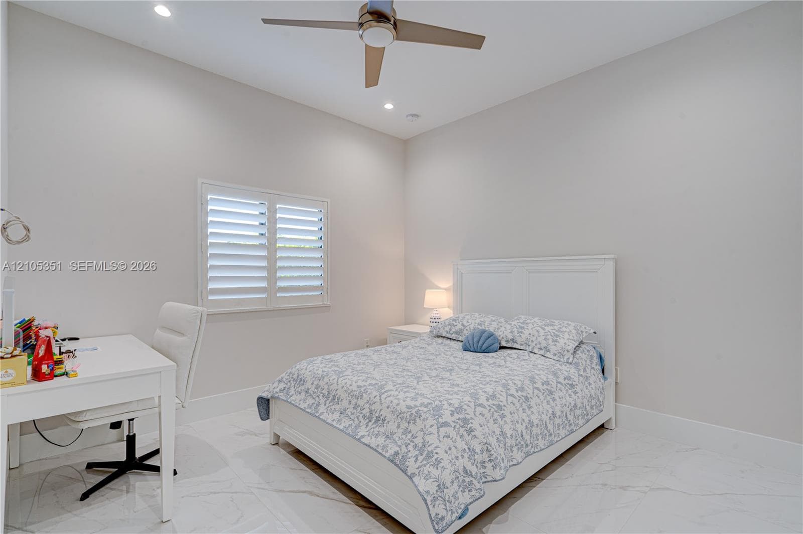 Neutral-toned bedroom featuring large-format tile flooring, recessed ceiling lighting, a contemporary ceiling fan, and plantation shutters