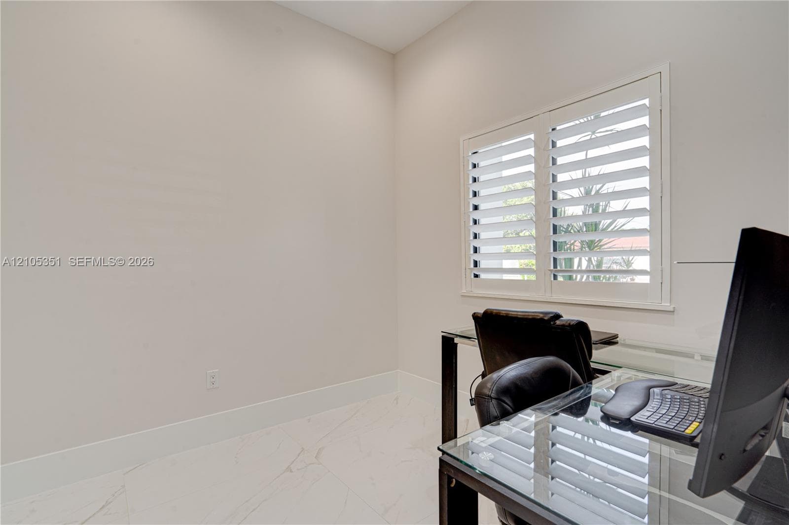 Neutral-toned interior featuring large-format tile flooring and window shutters