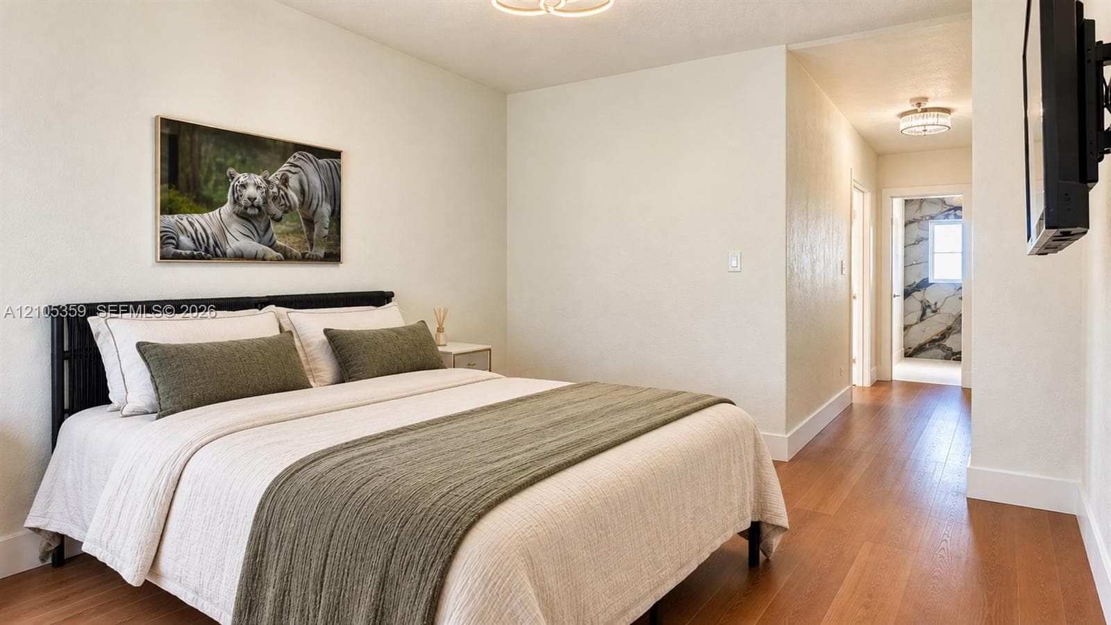 Wood-finish flooring throughout, modern flush-mount lighting, and a contemporary semi-flush mount fixture in the hallway