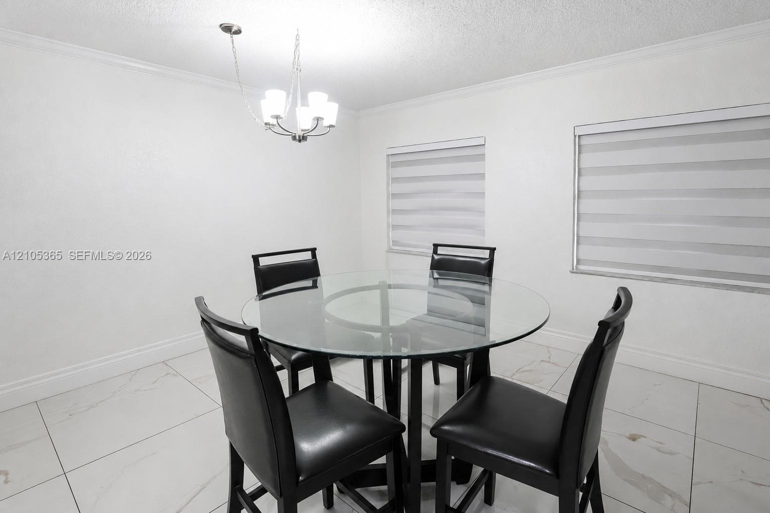 Recessed lighting, crown molding, two windows with blinds, and large format floor tile