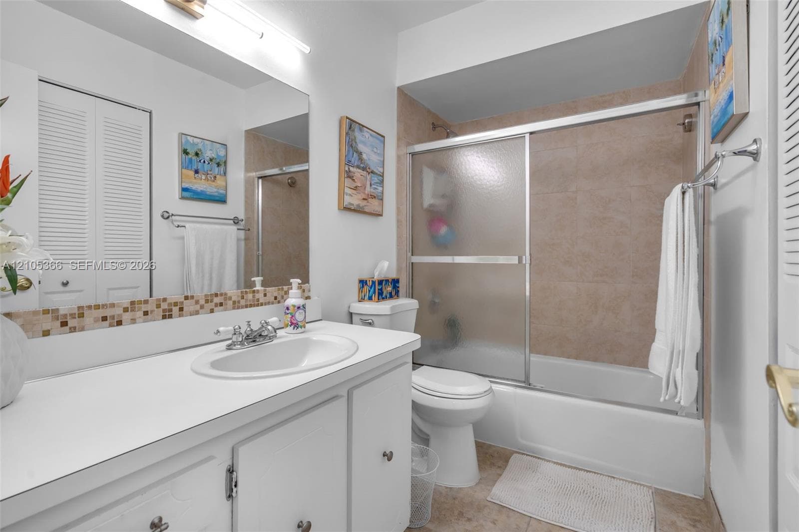 Bathroom featuring a single vanity, integrated sink, and mosaic tile backsplash