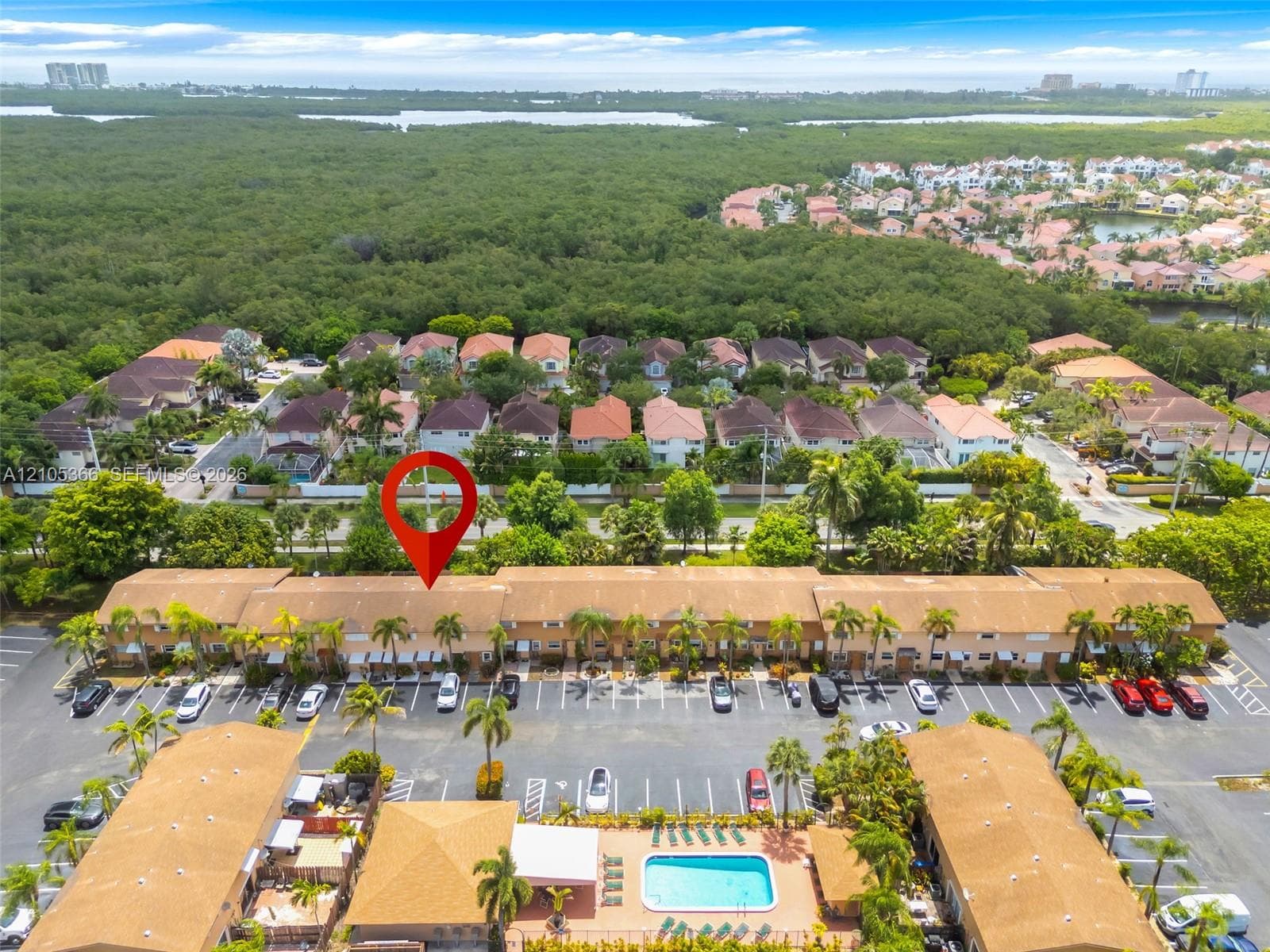 Community featuring multiple residential structures, parking areas, and a central swimming pool