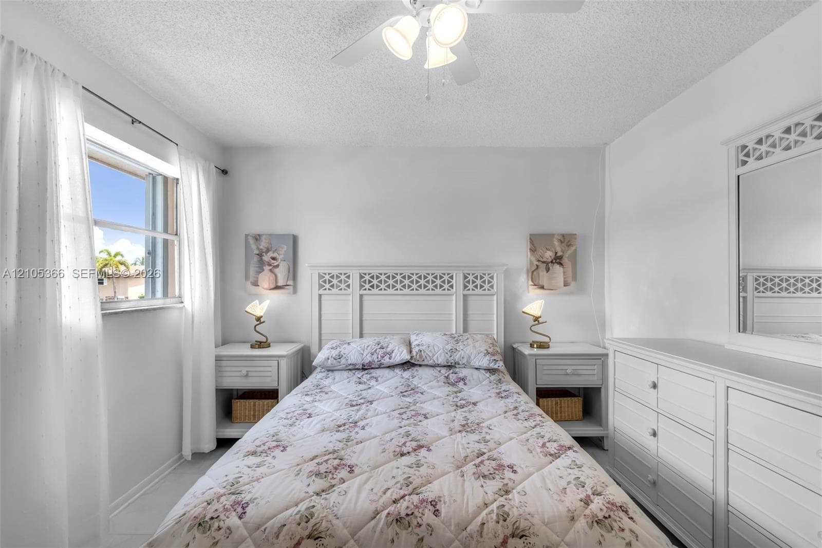 White walls, window with natural light, and a ceiling fan with integrated lighting