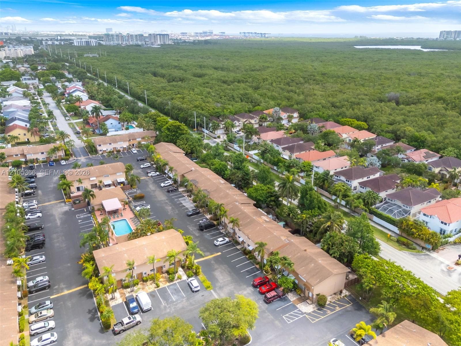 Aerial view of a residential community with mature trees and a wooded natural area