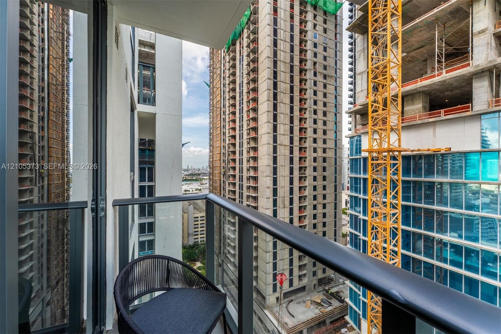 Balcony with glass panel railing and dark metal handrail