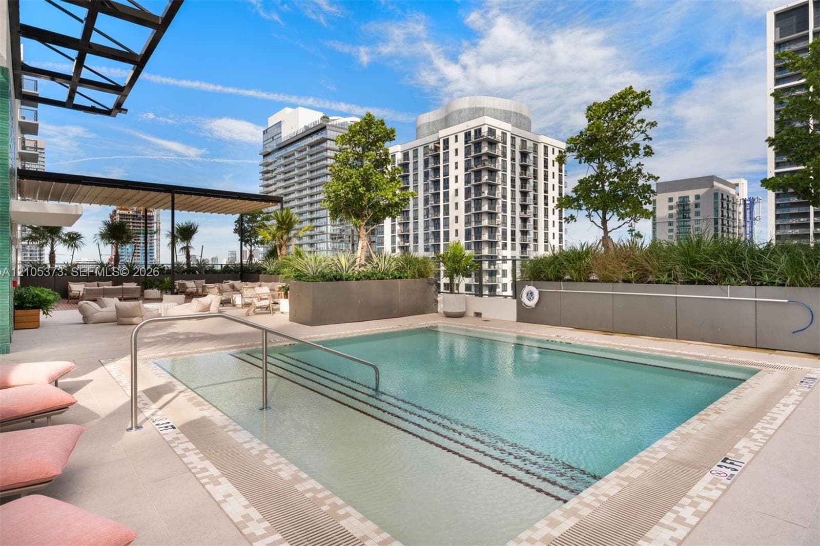 Rooftop pool with integrated steps, surrounded by a paved deck and integrated planters