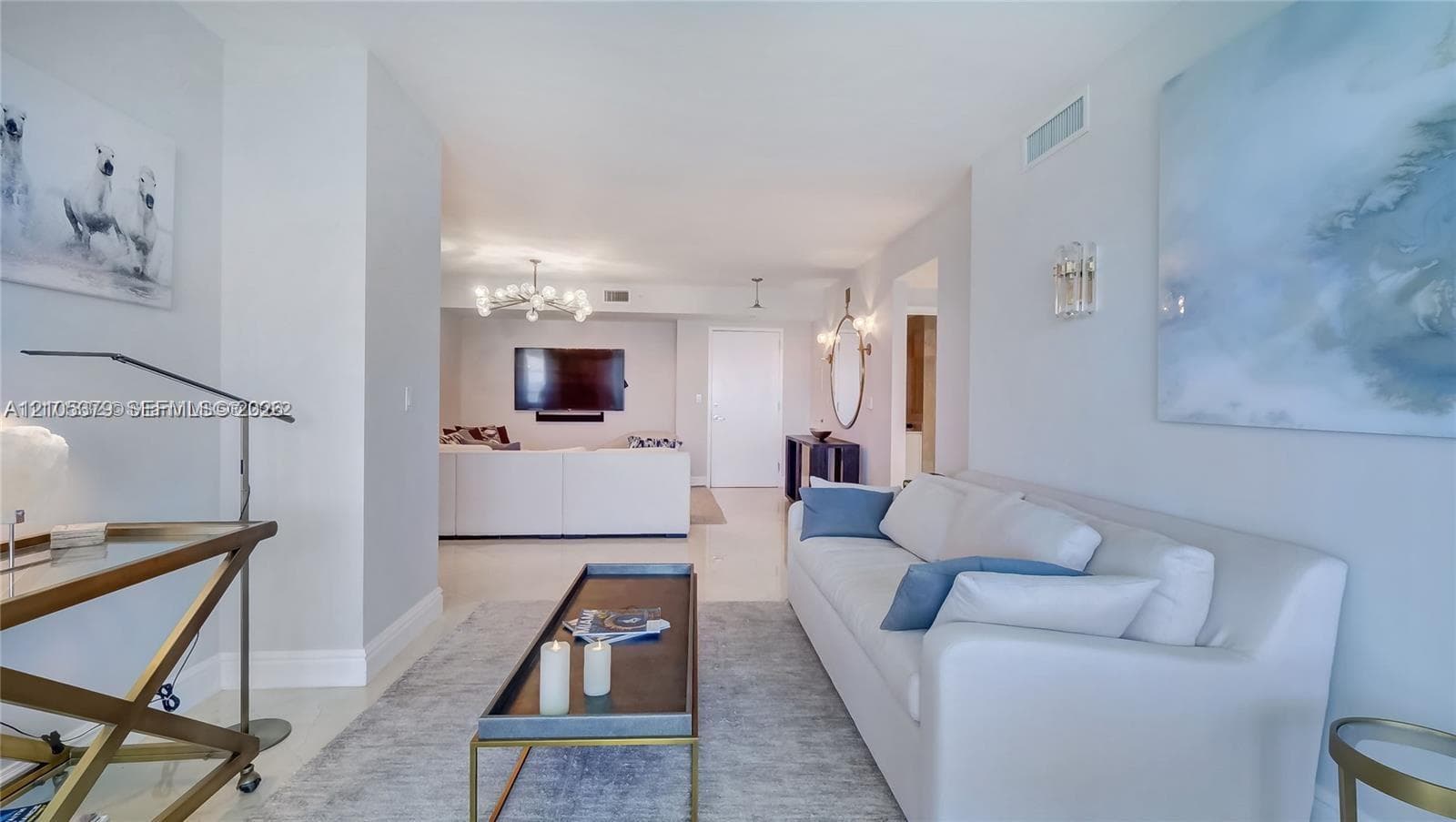 Recessed lighting, light-toned flooring, and an open-concept layout define this living space