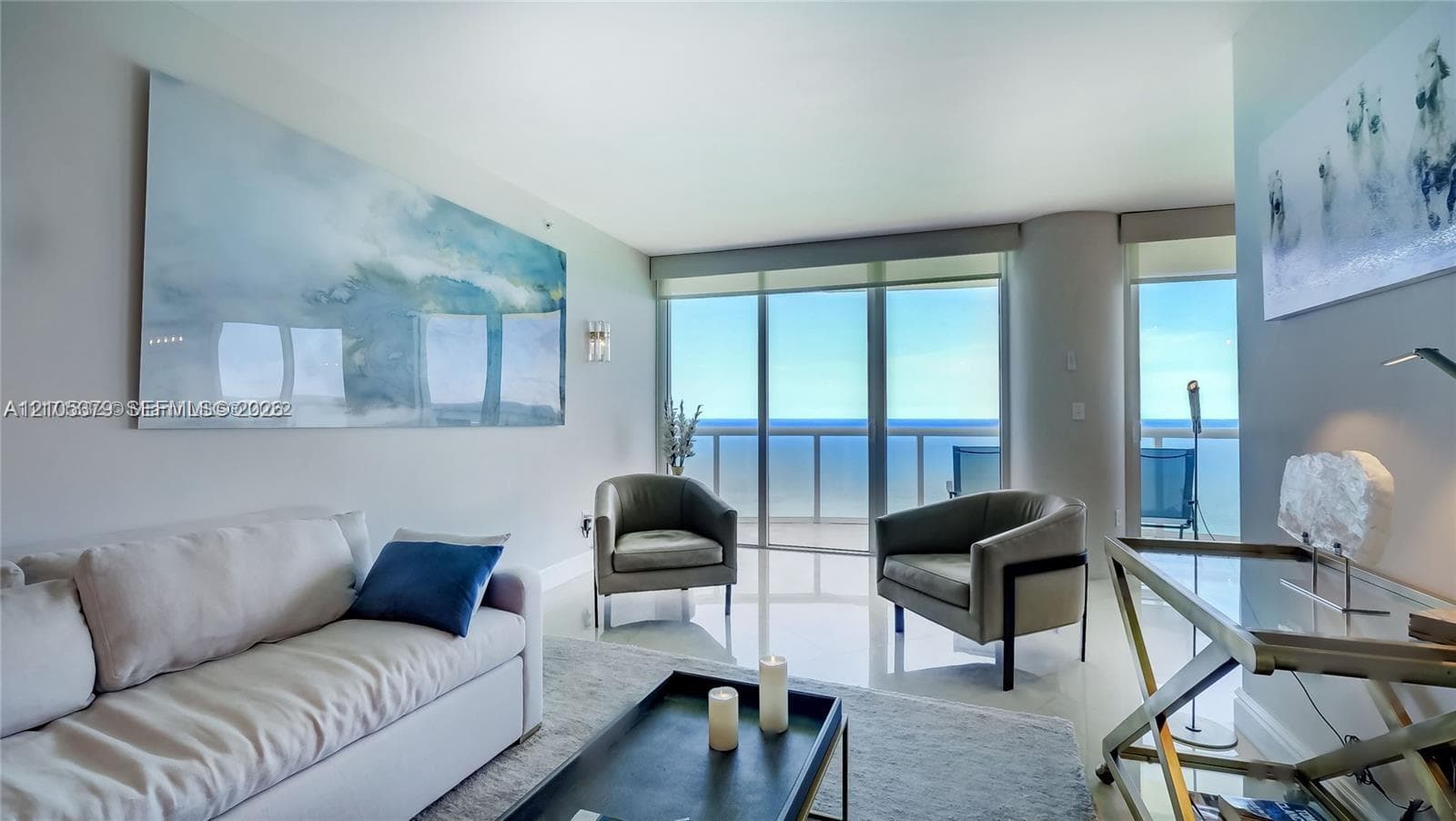 Floor-to-ceiling windows, light-toned tile flooring, recessed ceiling lighting, and wall sconces