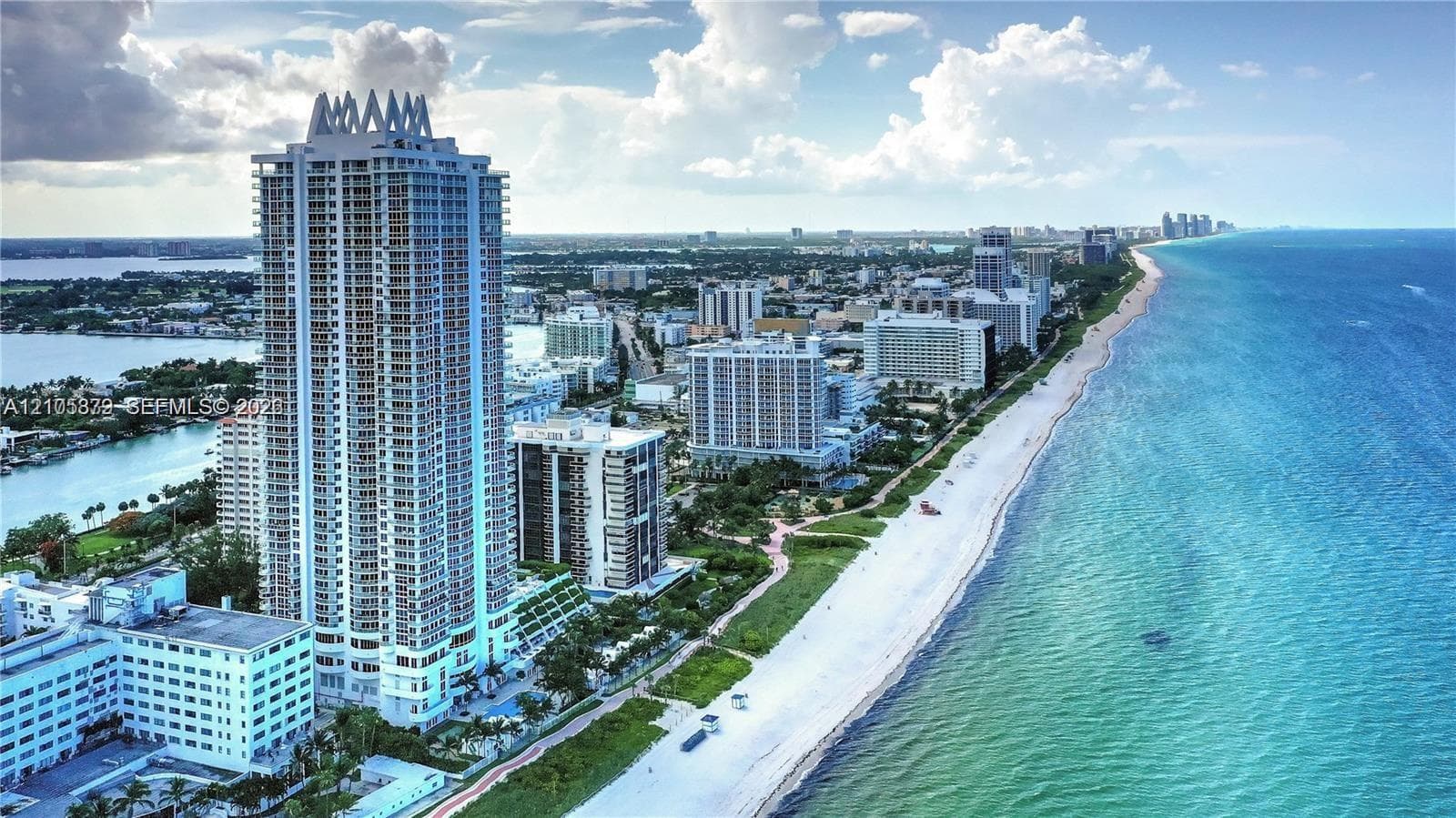 High-rise coastal tower featuring extensive balcony configurations, direct beach access, proximity to the Atlantic Ocean, and panoramic shoreline surroundings