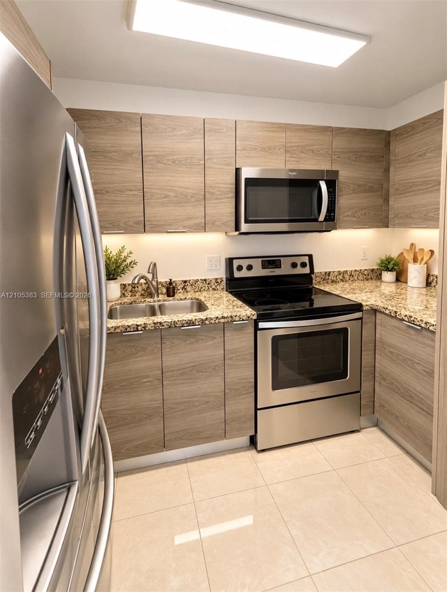 Kitchen featuring wood-finish cabinetry, stainless steel appliances, granite countertops, and tile flooring