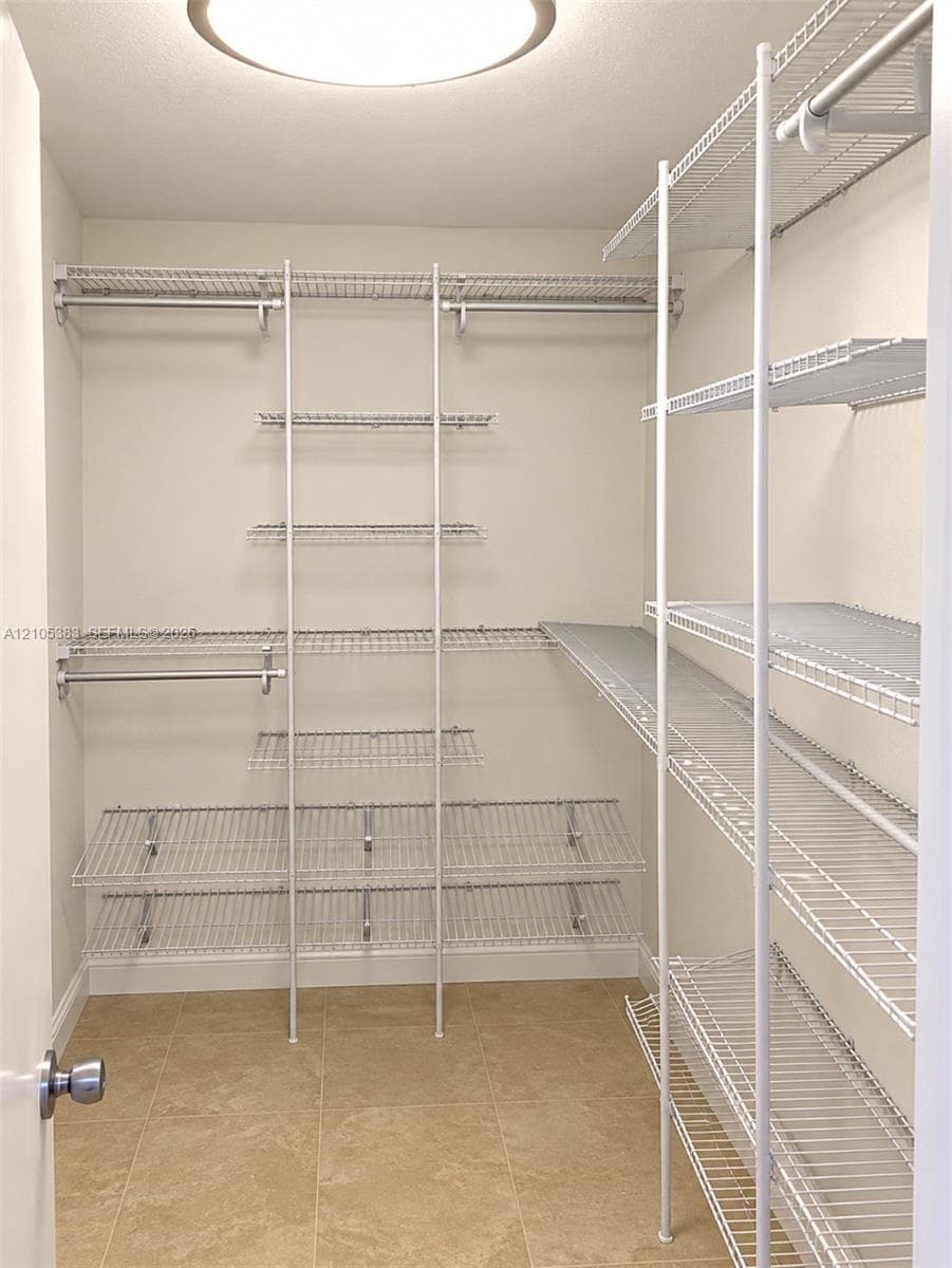 Customizable wire shelving system with multiple storage rods, recessed ceiling light, and tile flooring