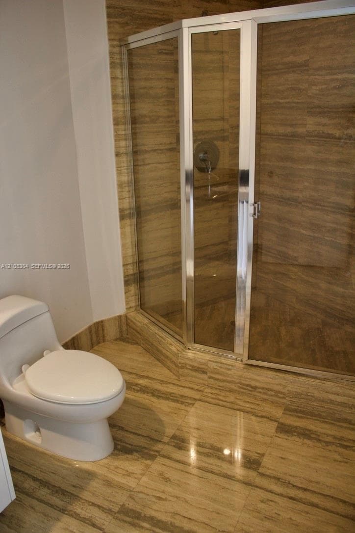 Glass-enclosed shower with polished chrome fixtures