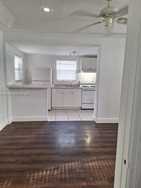 Wood-finish flooring, recessed lighting, and a ceiling fan